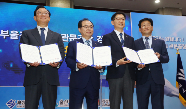24일 오후 부산시청 대회의실에서 열린 '부울경 동남권 관문공항 검증단 최종보고회'에서 송철호 울산시장과 오거돈 부산시장, 김경수 경남도지사가 검증보고회 뒤 국무총리에게 전달할 건의문을 들어보이고 있다. 정종회 기자 jjh@
