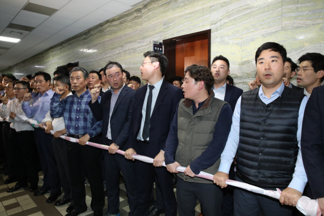 자유한국당 의원과 보좌진들이 25일 밤 여야4당의 수사권조정법안 제출을 막기 위해 국회 의안과 앞에서 인간벽을 쌓고 있다. 김종호 기자 kimjh@