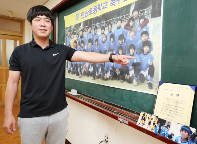 연산초 강민구 감독이 옛 축구부 사진에서 김현우를 가리키며 자랑스러워하고 있다. 강선배 기자 ksun@