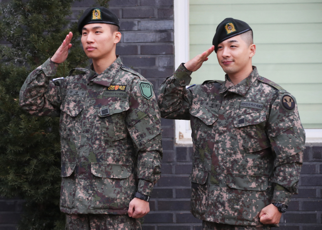 군 복무를 마친 그룹 빅뱅의 태양(오른쪽)과 대성이 10일 오전 경기도 용인시 지상작전사령부에서 나와 경례를 하고 있다. 연합뉴스