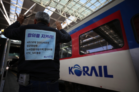19일 오후 서울역에서 한 직원이 등에 요구사항을 걸고 업무를 보고 있는 모습. 연합뉴스
