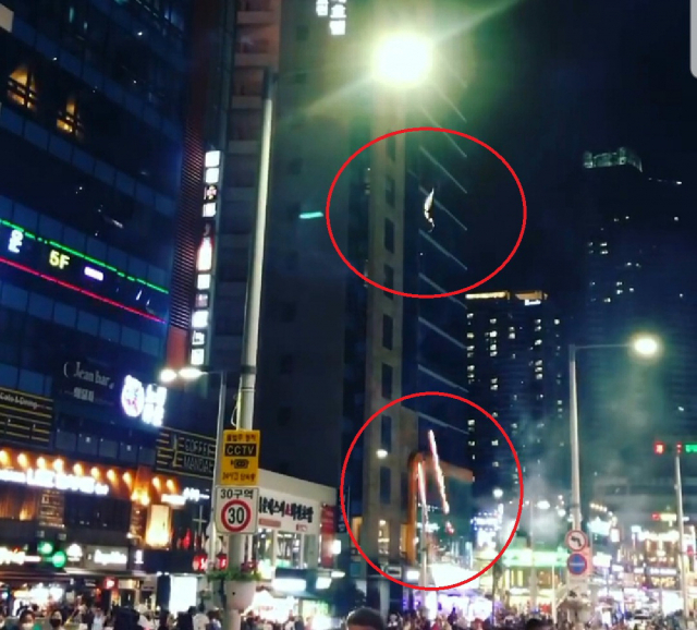 4일 밤 해운대해수욕장 인근 구남로에서 외국인들이 인근 건물을 향해 폭죽을 발사하는 모습. 독자 제공