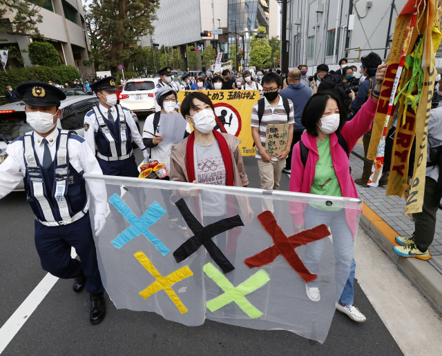 도쿄 올림픽 개최에 반대하는 일본 시민들이 지난 9일 올림픽 육상경기 테스트 대회가 열린 도쿄 신주쿠 국립경기장 주변에서 올림픽 취소를 촉구하는 시위를 벌이고 있다. 로이터연합뉴스