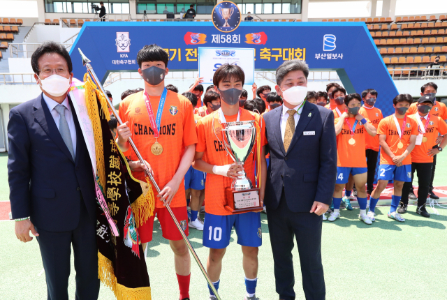 27일 제58회 청룡기 전국고등학교축구대회 시상식에서 대회를 주최한 부산일보사 김진수(왼쪽) 대표이사 사장과 대회를 후원한 고성군 백두현(오른쪽) 군수가 우승을 한 용인시축구센터U18덕영 선수 대표에게 우승기와 우승컵을 전달하며 격려하고 있다. 윤민호 프리랜서 yunmino@