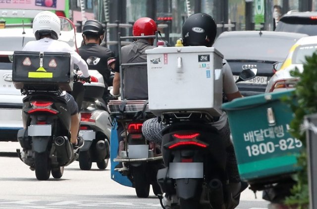 음식배달과 퀵서비스에 종사하는 배달원 수가 23만여명으로 3년 만에 배로 증가한 것으로 나타났다. 이들은 하루 평균 37~42건의 배달을 하고 월 순소득은 286만원으로 조사됐다. 사진은 배달 오토바이 기사들이 분주히 도심을 누비는 모습. 연합뉴스