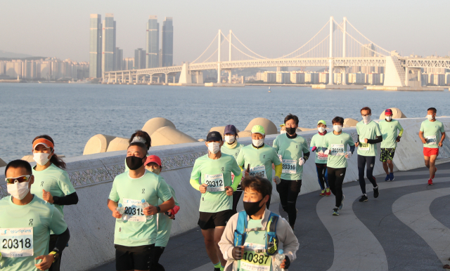 지난해 11월 열린 2020 부산바다마라톤 언택트레이스에 참가한 부산산악마라톤클럽 회원들이 해운대구 마린시티 인근에서 동백섬을 향해 마라톤을 하고 있다. 부산일보DB
