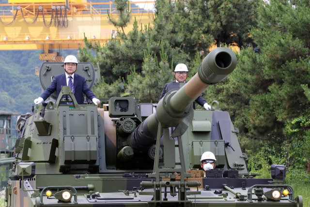 경남 창원에 있는 한화디펜스를 방문한 허성무(왼쪽) 창원시장이 회사 관계자들과 함께 K9 자주포를 탑승해 보고 있다. 창원시 제공