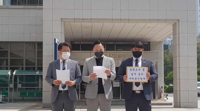 하윤수 후보 측 관계자가 25일 오전 부산지방법원 앞에서 '설문조사 실시 금지 가처분 신청'을 하며 기자회견을 열고 있다. 하윤수 캠프 제공