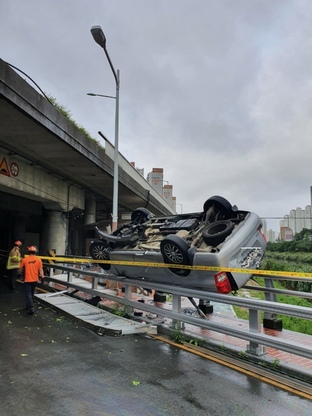 29일 수영강변대로에서 SUV 차량이 펜스를 뚫고 추락하는 사고가 발생했다. 부산소방본부 제공