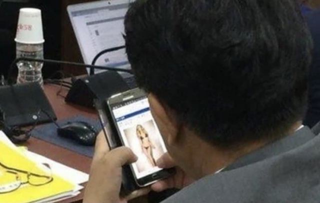 2014년 정부 세종청사에서 열린 국정감사 도중 비키니 입은 여성 사진 보는 권성동 의원. 부산일보 DB