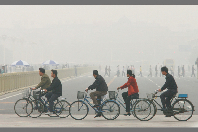 대기 오염으로 시야가 흐릿한 중국 베이징의 톈안먼광장 일원을 베이징 시민들이 자전거를 타고 주행하고 있다. 연합뉴스