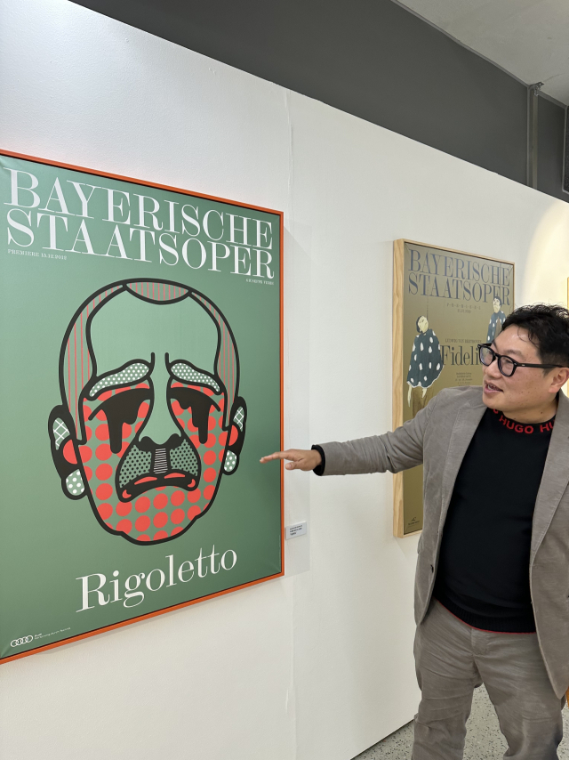 이상훈 아트컨시어지 대표가 팝아티스트 크랙 앤 칼이 디자인을 한 ‘바이에른 국립오페라극장 2012/13 시즌 포스터’ 앞에 서 있다. 김은영 선임기자