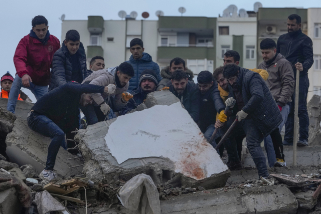 6일(현지시간) 튀르키예 남부 아다나에서 실종자 수색에 나선 시민들이 강진으로 붕괴한 건물 잔해를 들어올리고 있다. 시리아와 국경을 맞댄 지역에서 일어난 이번 지진으로 튀르키예와 시리아에서 현재까지 사망자가 4000명에 육박하고 있다. 연합뉴스