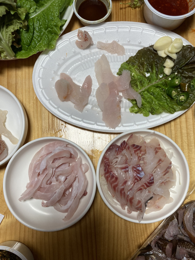 당일 숙소에서 먹은 자연산 회(사진 속 맨 위 접시). 우리가 직접 낚아 떠 온 회 접시가 가장 먼저 비었다. 시계방향으로 긴꼬리벵에돔회, 갈치회. 맨 오른쪽 아래 귀퉁이 살짝 보이는 회는 막 맛이 들기 시작한 제주 자리돔회.