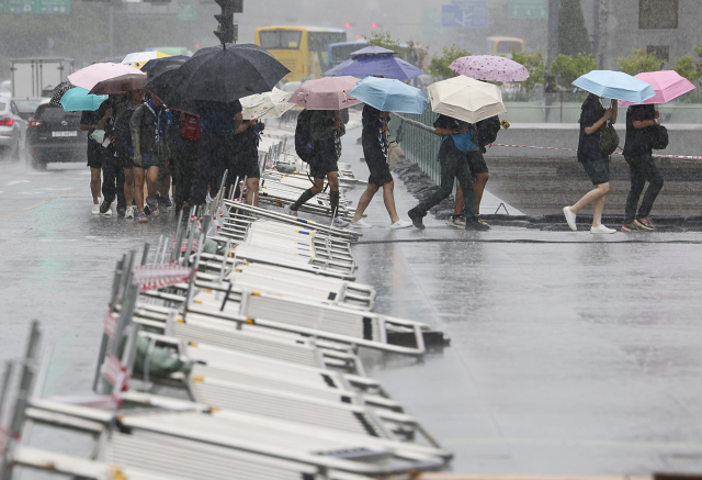 태풍 '카눈'이 북상 중인 10일 오후 서울 광화문 광장에서 대만 잼버리 참가 대원들이 우산을 쓴 채 걸어가고 있다. 연합뉴스
