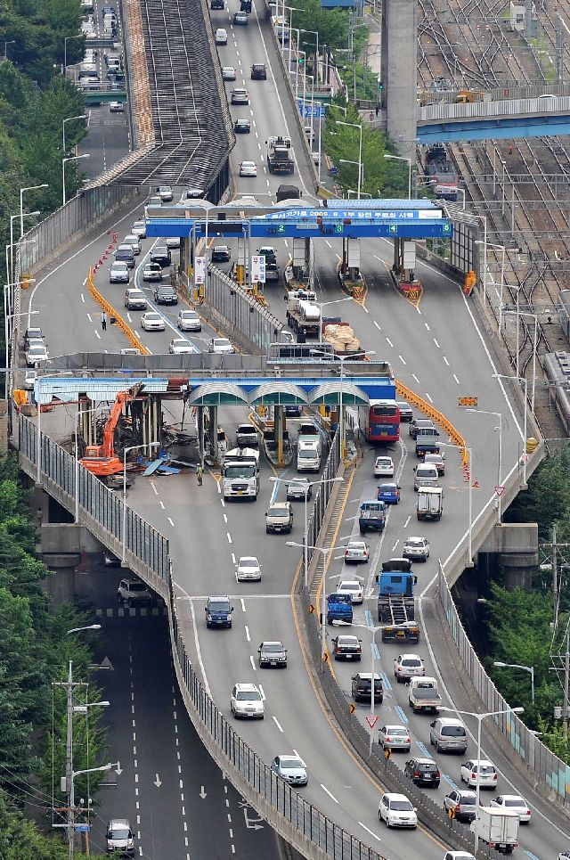 1992년 12월 개통 이후 17년 만인 2009년 8월 1일부터 무료화된 부산 동서고가로에서 2009년 8월 3일 오전 굴착기를 이용한 요금소 철거작업이 진행되고 있다. 부산일보DB