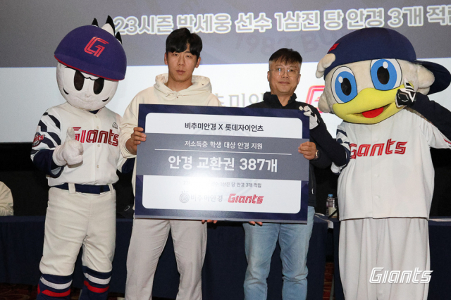 롯데 자이언츠 이정훈 선수(사진 왼쪽)가 지난 11월 25일 부산시 부산진구 롯데시네마 서면에서 열린 ‘사직오락관’ 행사 후 비추미안경 전우현 대표와 함께 기부금을 전달하고 있다. 롯데 자이언츠 제공