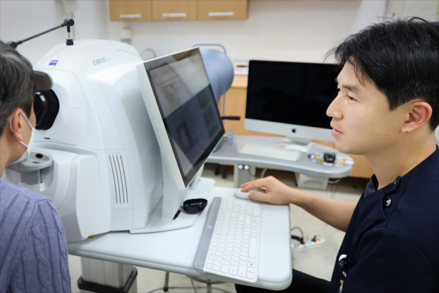 부산의료원 안과 박건형 과장이 빛간섭단층촬영 장비로 황반변성 환자를 검사하고 있다. 부산의료원 제공