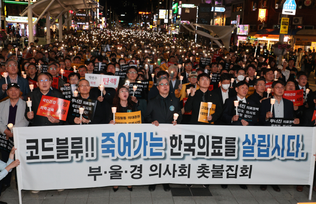 대한의사협회 소속 부산·울산·경남 의사들이 30일 오전 부산 해운대구 구남로에서 촛불집회를 열고 있다. 연합뉴스