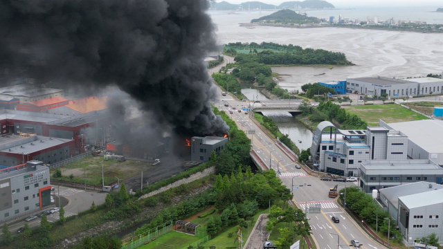 5일 오전 경기 화성시 전곡산업단지 내 한 공장에서 불이나 검은 연기가 피어오르고 있다. 소방당국은 오전 7시 23분께 대응 1단계를 발령했다. 불이 난 곳은 최근 근로자 23명이 사망한 일차전지 업체 공장 인근이다. 연합뉴스