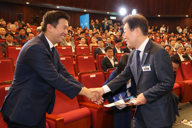 더불어민주당 차기 대표 후보인 이재명 전 대표(오른쪽)가 14일 오후 서울 여의도 국회도서관 강당에서 열린 더불어민주당 8·18 전당대회 최고위원 예비경선에서 김지수 후보와 악수하고 있다. 연합뉴스
