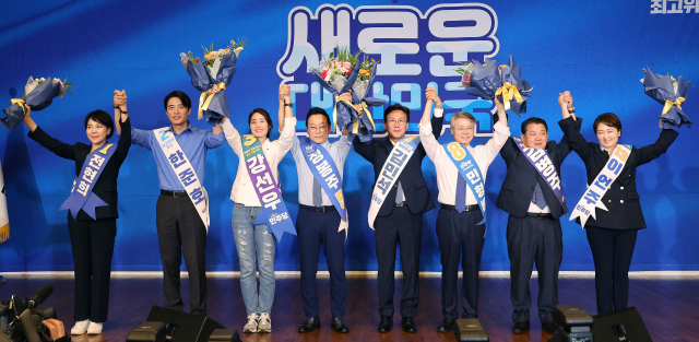 지난 14일 오후 서울 여의도 국회도서관 대강당에서 열린 더불어민주당 8·18 전당대회 최고위원 예비경선. 컷오프를 통과한 8명의 최고위원 후보들이 손을 들어 올리며 당원들에게 인사하고 있다. 왼쪽부터 전현희·한준호·강선우·정봉주·김민석·민형배·김병주·이언주 최고위원 후보. 연합뉴스