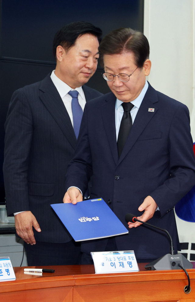 더불어민주당 김두관 당대표 후보와 이재명 후보가 지난 15일 오전 국회에서 제1회 전국당원대회 후보자 공명선거 실천 서약식에서 자리로 향하고 있다. 연합뉴스
