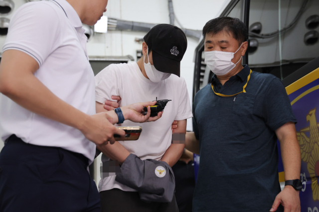 19일 오전 경기 의정부경찰서에서 경찰이 관원인 5세 아동을 심정지 의식불명 상태에 빠지게 한 혐의로 구속된 태권도 관장 A씨를 의정부지검으로 송치하고 있다. 연합뉴스