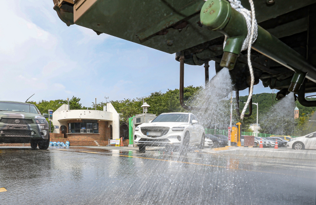 6일 오후 부산 남구 일대에서 해군작전사령부 K-10 제독차와 산악용 소방차가 아스팔트 열기를 식히기 위해 살수차로 운용되고 있다. 부산 남구는 다음달 13일까지 해군작전사령부 장비 3대와 인력을 지원 받아 폭염 대응 살수차로 운영한다. 김종진 기자 kjj1761@