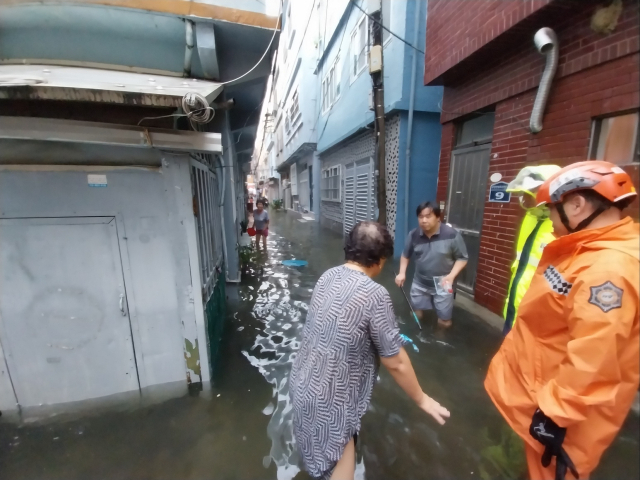 21일 오전 부산 부산진구 범천동에서 집안에 물이 가득찼다는 신고를 받고 출동한 소방이 안전조치를 하고 있는 모습. 부산소방재난본부 제공