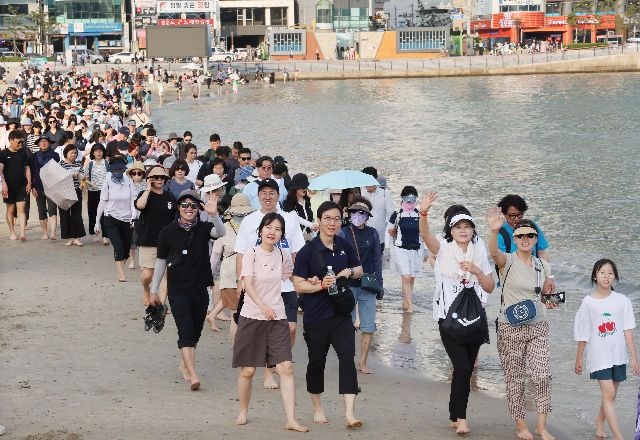 맨발걷기 좋은 도시 부산을 만들기 위해 기획된 부산 세븐비치 어싱 챌린지 두 번째 이벤트에서 참가자들이 광안리해수욕장을 맨발로 걷고 있는 모습(기사와는 관계 없음). 부산일보DB