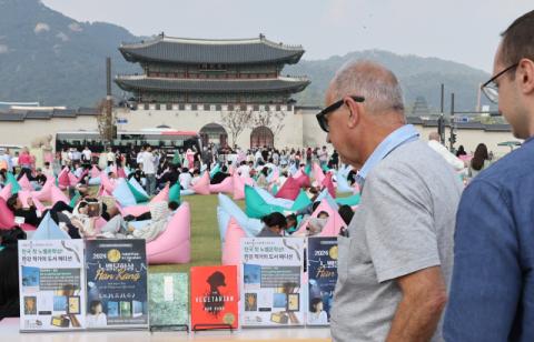 11일 서울 광화문광장 책마당 행사장에서 외국인이 노벨 문학상 수상자인 한강의 소설책을 보고 있다. 연합뉴스