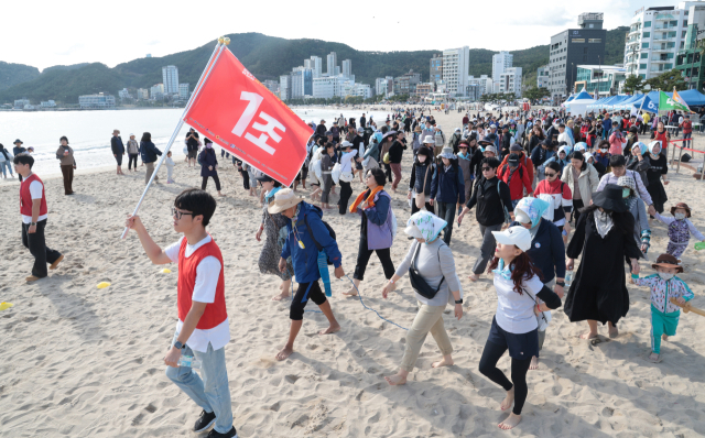 부산 바닷가 맨발걷기 축제인 ‘세븐비치 어싱 챌린지’ 송정해수욕장 편이 9일 진행돼 참가자들이 송정해수욕장을 맨발로 걷고 있다. 정대현 기자 jhyun@