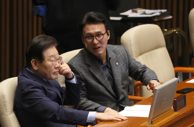 더불어민주당 이재명(왼쪽) 대표가 14일 국회 본회의에 참석해 김민석 최고위원과 대화하고 있다. 이날 본회의에서 김건희 여사 특검법 수정안에 대한 표결이 이뤄졌지만 국민의힘 의원들이 이에 항의해 퇴장했다. 연합뉴스