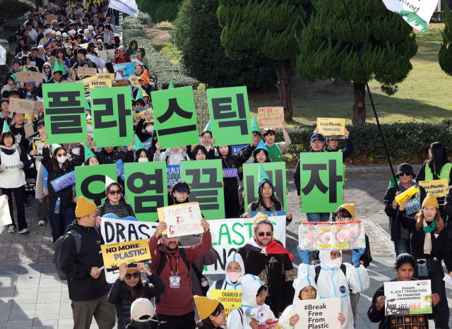 ‘플뿌리연대’ 회원들과 전 세계 환경단체 회원들이 23일 오후 강력한 플라스틱 협약을 촉구하며 회의가 개최되는 부산 벡스코 주위를 행진하고 있다. 정종회 기자 jjh@