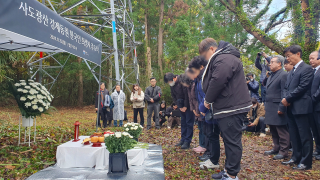 25일 일본 니가타현 사도광산 조선인 기숙사 터에서 열린 사도광산 강제동원 한국인 희생자 추도식에서 한국측 유족과 참석자들이 헌화한 뒤 묵념하고 있다. 연합뉴스