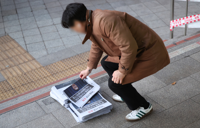 윤석열 대통령이 긴급 대국민 담화를 통해 비상계엄 해제를 선언한 4일 오전 서울 종로구 종각역 인근에서 시민들이 관련 내용이 적힌 호외를 가져가고 있다. 연합뉴스