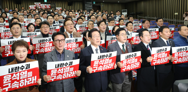 더불어민주당 이재명 대표(앞줄 왼쪽 세번째)와 박찬대 원내대표 등 의원들이 24일 오후 국회에서 열린 의원총회에 앞서 ‘내란수괴 윤석열을 구속하라!’라고 적힌 손팻말을 들고 구호를 외치고 있다. 연합뉴스