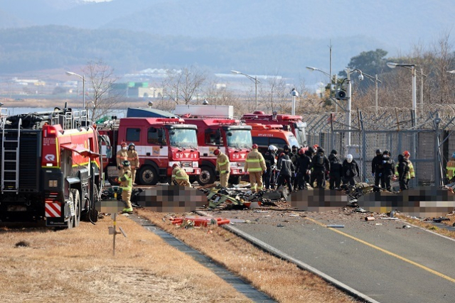 29일 오전 전남 무안국제공항에서 착륙 중이던 항공기가 활주로를 이탈해 울타리 외벽을 충돌했다. 사진은 사고 현장에서 소방 당국이 인명 구조를 하는 모습. 연합뉴스