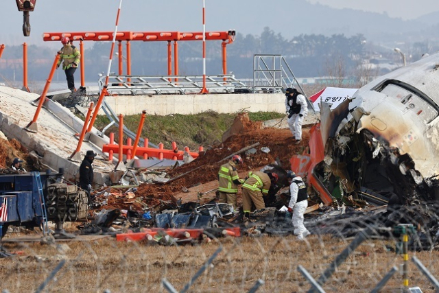 30일 전남 무안군 무안국제공항 제주항공 여객기 충돌 폭발 사고 현장에서 경찰 과학수사대가 활주로 인근의 방위각 시설(로컬라이저)을 살피고 있다. 연합뉴스