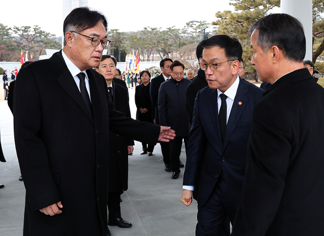 최상목 대통령 권한대행 부총리 겸 기획재정부 장관이 2025년 새해 첫날인 1일 국립서울현충원을 찾아 현충탑 참배 뒤 정진석 대통령 비서실장과 대화하고 있다. 연합뉴스