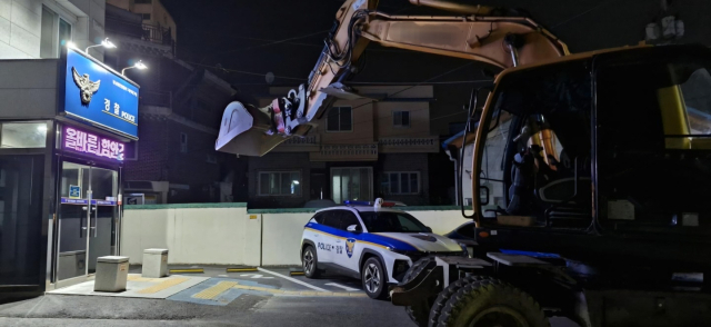 지난 13일 오전 3시 20분께 경남 함안군 한 지구대 앞에서 50대 남성이 굴삭기를 몰고 와 버킷을 치켜올리며 위협하고 있다. 함안경찰서 제공