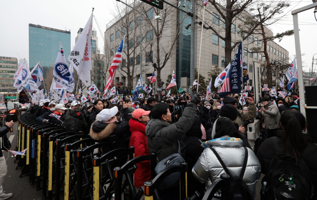 16일 윤석열 대통령 체포적부심사가 열린 서울 서초구 중앙지방법원 앞에서 윤 대통령 지지자들이 태극기를 흔들고 있는 모습. 연합뉴스