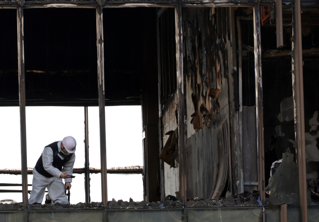 16일 오전 부산 기장군 오시리아 관광단지 오랑대공원 인근의 '반얀트리 해운대 부산' 공사 현장에서 진행된 합동감식에서 감식팀 관계자가 당시 불이 처음 시작된 것으로 추정되는 B동 1층을 집중적으로 살펴보고 있다. 지난 14일 오전에 발생한 화재로 작업자 6명이 숨지고, 27명이 연기 흡입 등 경상을 입었다. 연합뉴스