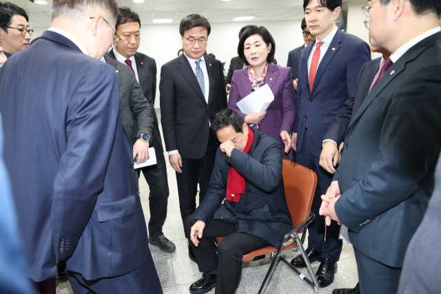 마은혁 헌법재판관 임명 반대 단식농성을 벌이고 있는 국민의힘 박수영 의원이 6일 서울 여의도 국회 소통관을 찾아 더불어민주당 이재명 대표의 부산 방문에 반대하는 기자회견에 참석했다. 기자회견에 동참한 국민의힘 부산 지역 의원들이 힘들어하는 박 의원에게 단식을 중단하고 병원 치료를 받으라고 설득하고 있다. 연합뉴스