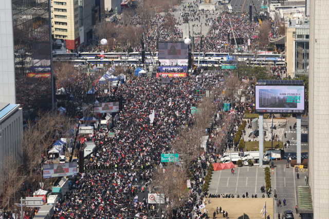 8일 서울 종로구 동화면세점 앞에서 열린 탄핵 반대 광화문 국민대회에서 참가자들이 태극기와 손팻말을 흔들고 있다. 연합뉴스