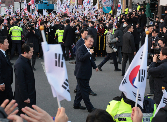 서울구치소에서 석방된 윤석열 대통령이 8일 서울 한남동 관저 앞에서 차량에서 내려 주먹을 불끈 쥐며 지지자들에게 인사하고 있다. 연합뉴스