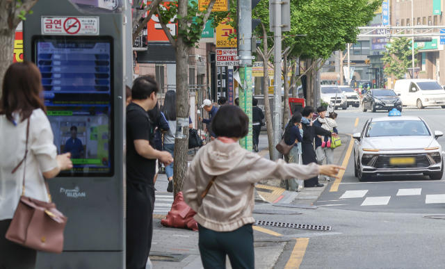 부산지역 시내버스가 전면 파업에 돌입한 28일 오전 부산 연제구 연산교차로 버스정류장에서 시민들이 장시간 기다려도 대체버스가 오지 않자 급하게 택시를 잡고 있다. 김종진 기자 kjj1761@