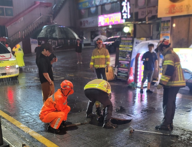 소방 당국이 14일 오전 부산 연제구 연산동 한 거리에서 맨홀 정비를 하고 있다. 부산소방재난본부 제공