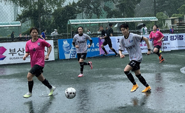 14일 부산 해운대카파풋살구장에서 열린 부산 여성체육대회 풋살 경기에서 사하구청과 사상구청 소속 선수들이 빗속에서 경기를 펼치고 있다. 부산시체육회 제공